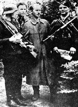 Fotografia czterech partyzantów BCH, w środku w płaszczu Jan Sońta „Ośka”, obok z prawej Władysław Gołąbek „Boryna”, 1944 r. [ze zbiorów MHPRL w Warszawie].